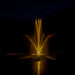 View of fountain in pond using the Bearon Aquatics Artemis Nozzle at night with yellow LED lights | Your Pond Pros 