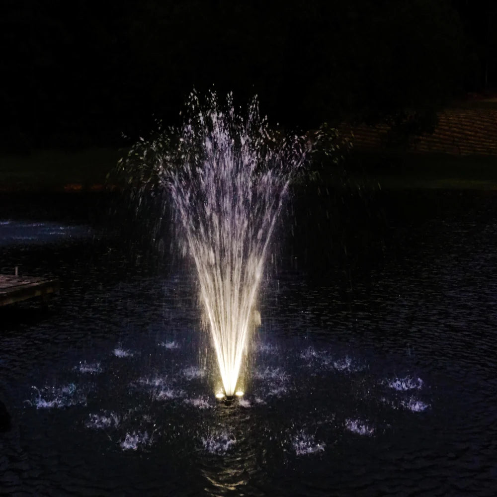 Fountain in a pond at night with white LED lights using the Bearon Aquatics Eros Nozzle | Your Pond Pros